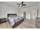 Inviting bedroom featuring a ceiling fan, soft lighting, and wood laminate flooring at 1203 Custer Bayou Street, Ruskin, FL 33570