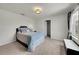 Bright bedroom featuring neutral walls, carpet flooring and a cozy queen bed at 1203 Custer Bayou Street, Ruskin, FL 33570