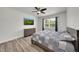 Comfortable bedroom with ceiling fan, window view, and wood laminate flooring at 1203 Custer Bayou Street, Ruskin, FL 33570