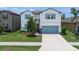 Charming two-story home boasts blue shutters, a well-manicured lawn, and an attached two car garage at 1203 Custer Bayou Street, Ruskin, FL 33570