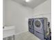Functional laundry room with modern washer and dryer units for convenience at 1203 Custer Bayou Street, Ruskin, FL 33570