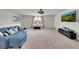Spacious living room with a blue couch, plush carpet, and a window with curtains at 1203 Custer Bayou Street, Ruskin, FL 33570