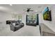 Open concept living room featuring comfortable gray seating and a mounted TV on a brick wall at 1203 Custer Bayou Street, Ruskin, FL 33570