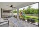 Relaxing screened patio featuring furniture, a ceiling fan, and a scenic backyard view at 1203 Custer Bayou Street, Ruskin, FL 33570