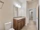 Bathroom featuring granite countertop, dark wood cabinetry, vanity mirror, and toilet at 1229 Hillandale Reserve Dr, Tampa, FL 33613