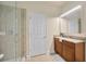 Bright bathroom features a glass enclosed shower, wood cabinets with granite countertops, and tile flooring at 1229 Hillandale Reserve Dr, Tampa, FL 33613
