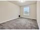Inviting bedroom features a bright window, plush carpeting, neutral walls, and baseboard trim throughout at 1229 Hillandale Reserve Dr, Tampa, FL 33613