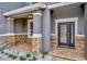 Stylish front porch showcasing stone details, a decorative front door, and tiled flooring, creating a warm entry at 1229 Hillandale Reserve Dr, Tampa, FL 33613