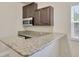 Elegant wet bar features granite countertops, stainless steel microwave, and wooden cabinets at 1229 Hillandale Reserve Dr, Tampa, FL 33613