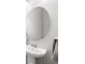 Elegant bathroom featuring a pedestal sink, chrome faucet, and oval mirror at 12353 Bayou Flats Ln, Tampa, FL 33635