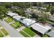 Neighborhood aerial view featuring lush greenery, well-kept lawns, and a screened-in pool at 1263 Overcash Dr, Dunedin, FL 34698