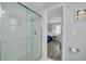 Updated shower with glass door leading to stylish bedroom with wood floors at 1263 Overcash Dr, Dunedin, FL 34698