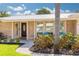 This home's charming front entrance features a beautifully landscaped yard and inviting curb appeal at 1263 Overcash Dr, Dunedin, FL 34698