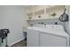 Functional laundry room featuring modern washer, dryer, sink, and built-in shelving at 1263 Overcash Dr, Dunedin, FL 34698