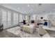 Spacious living room with stylish furnishings, plantation shutters, and a decorative rug adding warmth to the gray floors at 1263 Overcash Dr, Dunedin, FL 34698
