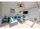 This covered patio features a seating area with a fan, TV and beach decor creating a relaxing outdoor space at 1263 Overcash Dr, Dunedin, FL 34698