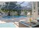 The screened-in pool is surrounded by lush greenery offering a private and refreshing outdoor retreat at 1263 Overcash Dr, Dunedin, FL 34698