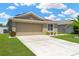 Charming home showcasing a manicured lawn, long driveway, and a two-car garage at 12925 Fieldmoor Ct, Riverview, FL 33579