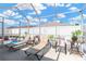 Screened patio with lounge chairs, a table, and clear views of the sky and the white perimeter fence at 12925 Fieldmoor Ct, Riverview, FL 33579