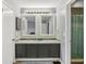 Bathroom featuring double sinks with granite countertops, decorative mirrors and modern lighting at 16076 Dawnview Dr, Tampa, FL 33624