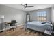 This bedroom features a ceiling fan, desk, and large windows for ample natural light at 16076 Dawnview Dr, Tampa, FL 33624