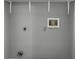 A blank laundry room wall with plumbing, electrical hookups and shelf supports at 16076 Dawnview Dr, Tampa, FL 33624
