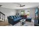 Comfortable living room with large sofa, sleek ceiling fan, and sliding glass door at 16076 Dawnview Dr, Tampa, FL 33624