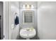 Cozy powder room features a pedestal sink, decorative mirror, and modern faucet fixture at 16076 Dawnview Dr, Tampa, FL 33624