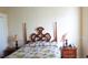 Bright bedroom with a four poster bed, tropical themed bedding, and matching lamps for nighttime reading at 16515 Nikki Ln, Odessa, FL 33556