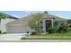 Charming single-story home with a well-manicured lawn, two-car garage, and inviting front entrance at 16515 Nikki Ln, Odessa, FL 33556