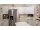 Bright kitchen boasting stainless steel refrigerator, white cabinets, and ample counter space at 16515 Nikki Ln, Odessa, FL 33556