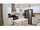 Modern kitchen featuring white cabinets, stainless steel appliances, and a center island at 16515 Nikki Ln, Odessa, FL 33556