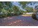 Large brick patio surrounded by mature trees and a well-kept lawn, perfect for outdoor entertaining at 1766 Hitching Post Ln, Dunedin, FL 34698