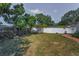 Green backyard with a combination of chain link and white vinyl fencing, offering privacy and space at 1766 Hitching Post Ln, Dunedin, FL 34698