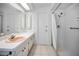 Bathroom features a shower with a full-length curtain, large mirror, and updated vanity at 1766 Hitching Post Ln, Dunedin, FL 34698