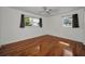 Bedroom features hardwood flooring, a ceiling fan, and natural lighting from the windows at 1766 Hitching Post Ln, Dunedin, FL 34698