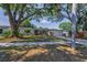 Charming home with a well-manicured lawn, mature trees, and colorful landscaping, offering inviting curb appeal at 1766 Hitching Post Ln, Dunedin, FL 34698