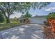 Inviting one-story home with an attached garage, complemented by a green lawn and mature trees at 1766 Hitching Post Ln, Dunedin, FL 34698