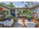 Inviting entryway showcasing a stylish front door surrounded by lush plants and mulch beds at 1766 Hitching Post Ln, Dunedin, FL 34698