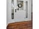 Elegant white front door with decorative glass and sidelights, set against warm hardwood floors at 1766 Hitching Post Ln, Dunedin, FL 34698