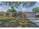 Charming single-story home featuring a well-maintained lawn and colorful landscaping, creating a welcoming curb appeal at 1766 Hitching Post Ln, Dunedin, FL 34698