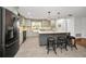 Modern kitchen with an island, stone backsplash, stainless appliances, and neutral-colored cabinets at 1766 Hitching Post Ln, Dunedin, FL 34698