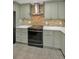 Modern kitchen featuring granite counters, updated appliances, tile backsplash, and neutral-colored cabinets at 1766 Hitching Post Ln, Dunedin, FL 34698