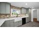 Bright kitchen featuring stone backsplash, stainless appliances, and a farmhouse sink with a view to the yard at 1766 Hitching Post Ln, Dunedin, FL 34698