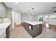 Open kitchen features a large island, and a view of the adjacent living room with wood floors at 1766 Hitching Post Ln, Dunedin, FL 34698