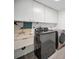 Convenient laundry room with modern washer and dryer, sink, and ample storage at 1766 Hitching Post Ln, Dunedin, FL 34698
