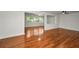 Open-concept living room with wood floors, a ceiling fan, and a wall of windows allowing for natural light at 1766 Hitching Post Ln, Dunedin, FL 34698