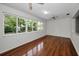 Bright sunroom with large windows and brick accent wall with hardwood flooring at 1766 Hitching Post Ln, Dunedin, FL 34698