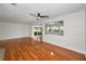 Bright living room featuring wood floors, sliding glass doors to the yard, and a modern ceiling fan at 1766 Hitching Post Ln, Dunedin, FL 34698