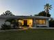 Inviting home exterior with a well-manicured lawn and mature palm trees in a tranquil setting at 1775 62Nd S Ter, St Petersburg, FL 33712
